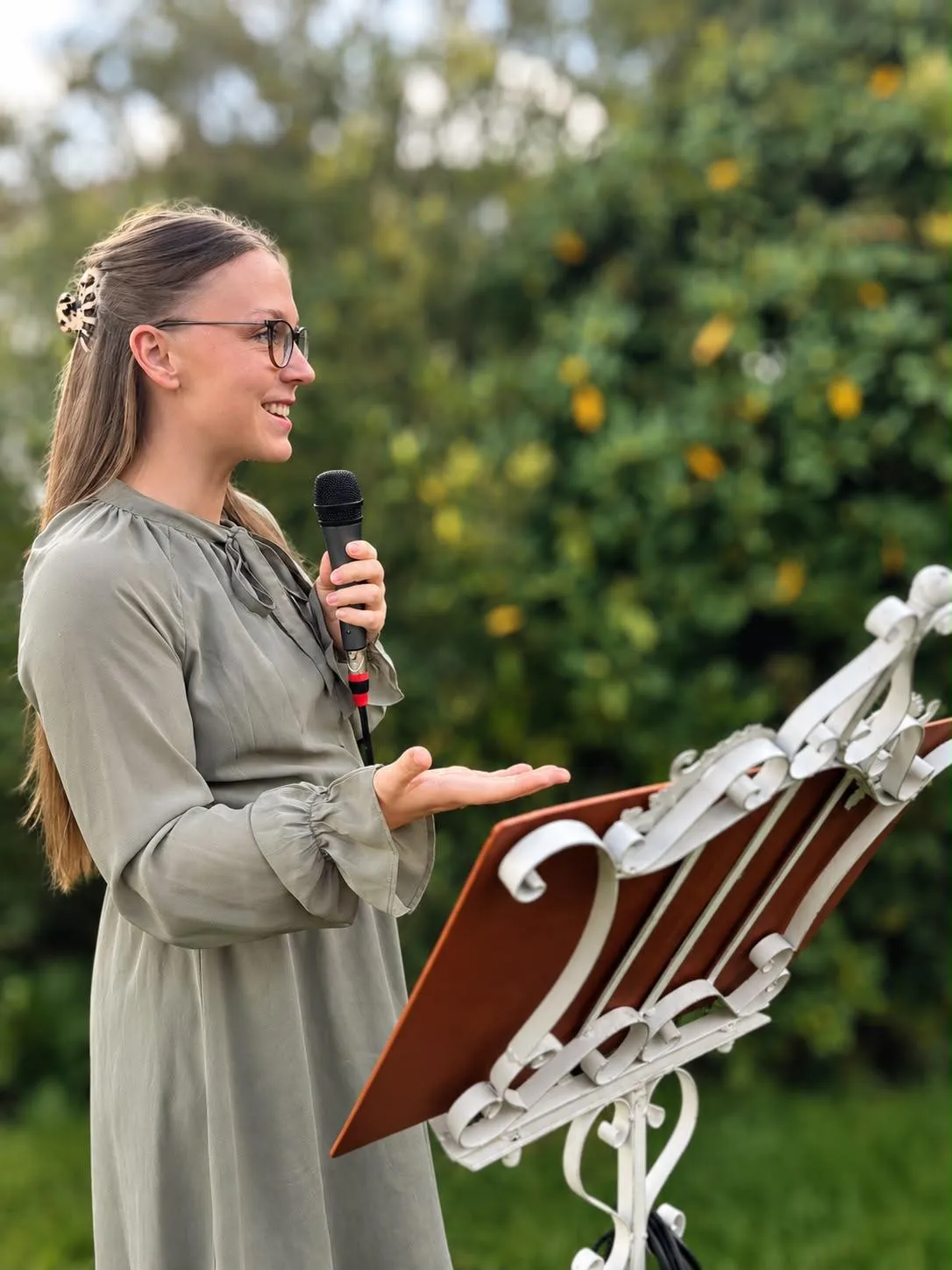 Maren Müller spricht mit Mikrofon am Rednerpult im Freien